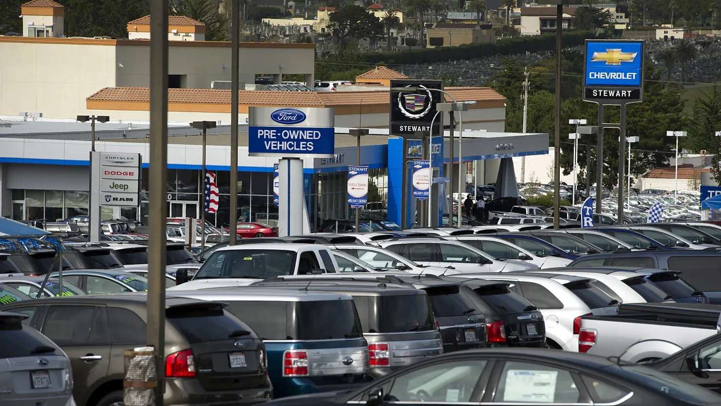Many pre-owned cars are standing in a dealership
