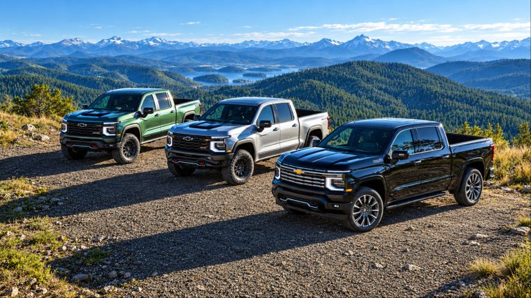 Three Chevrolet Silverado trucks parked on mountain overlook scenic view