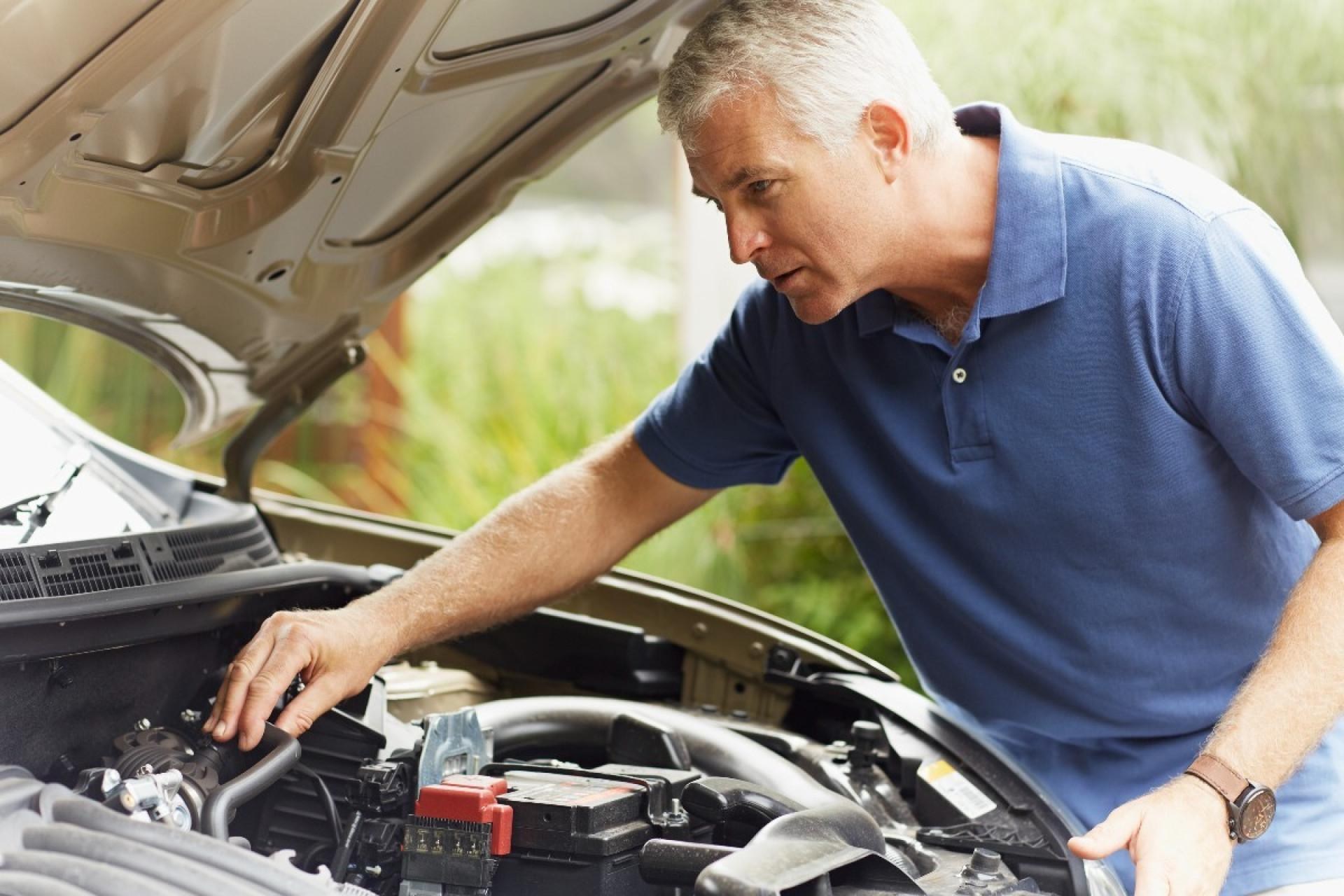 Driver Inspecting Engine Before Roadtrip