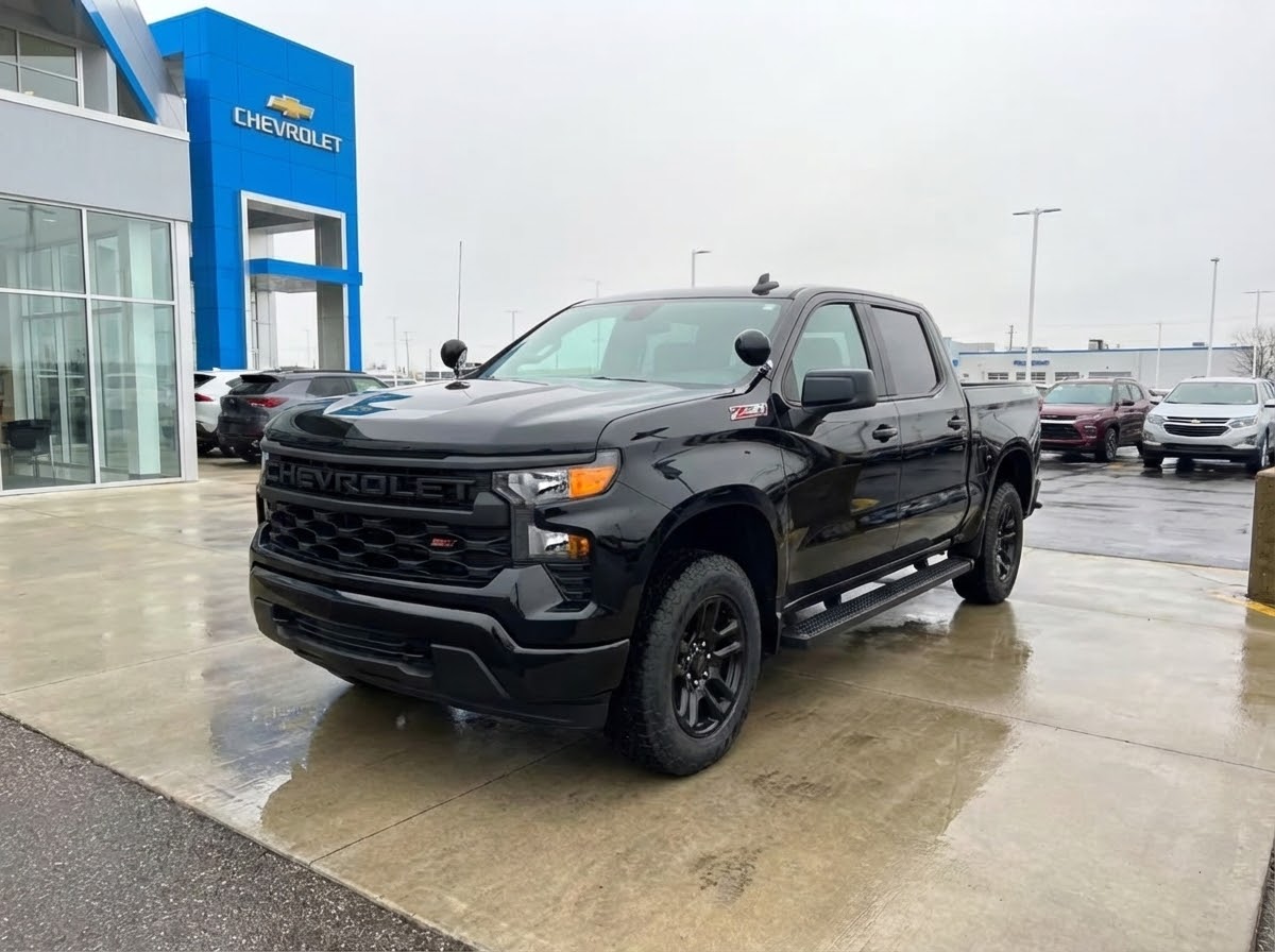 A Chevrolet Silverado is standing in front of a dealership