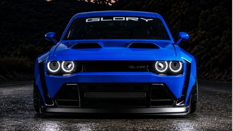 Blue modified Dodge Challenger with Glory branding on wet road