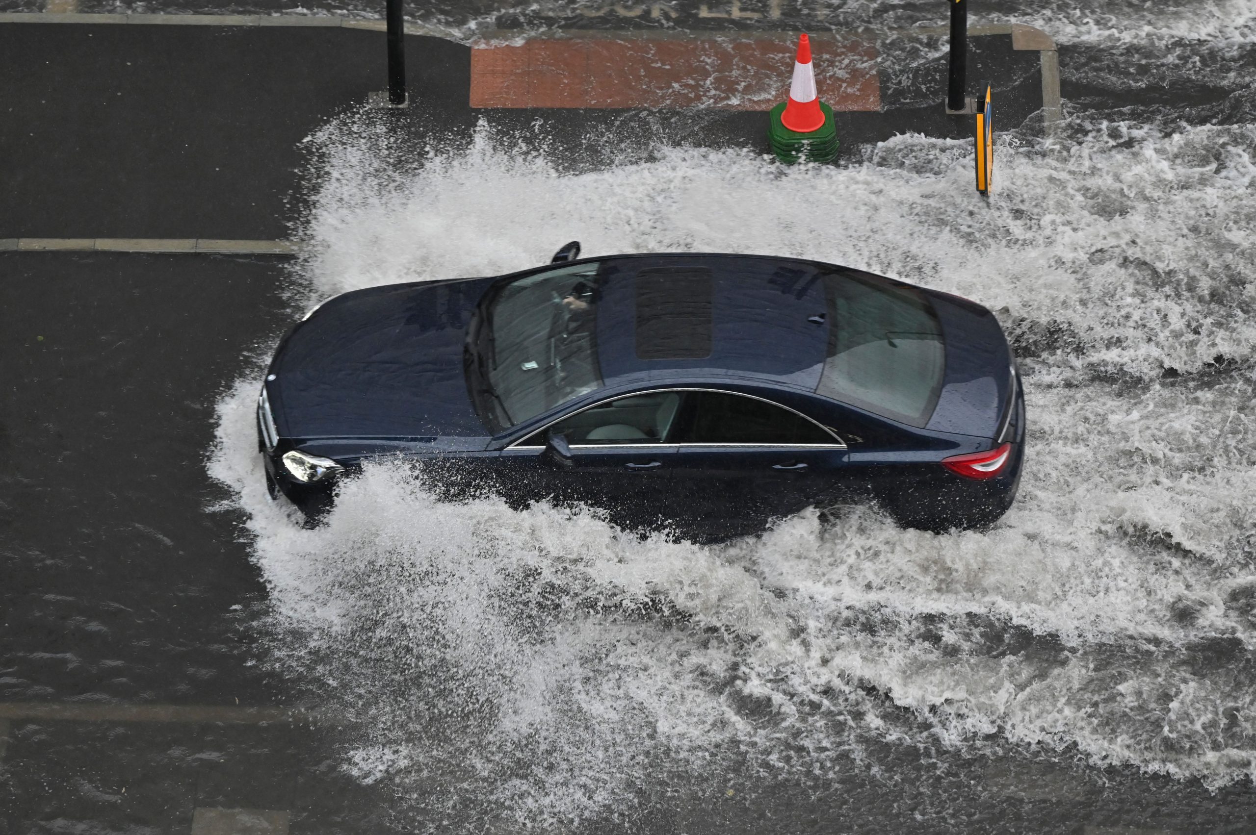A car is driving through huge water blockage