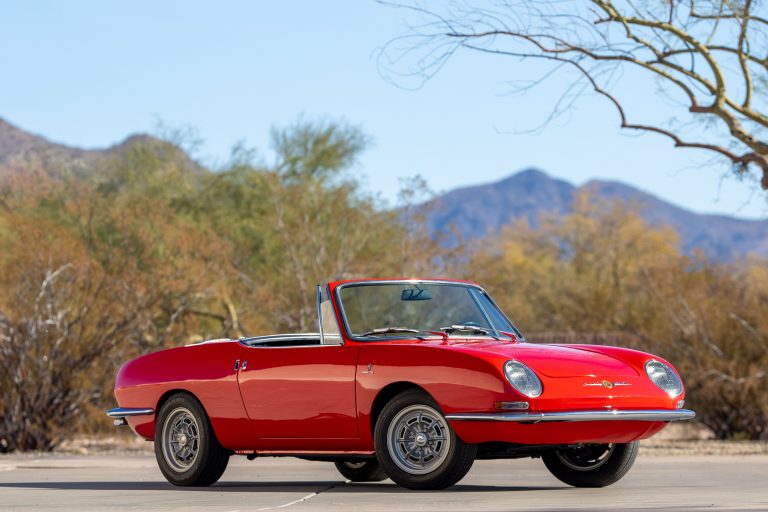 A Spider 850 in shiny red is standing on a flat road