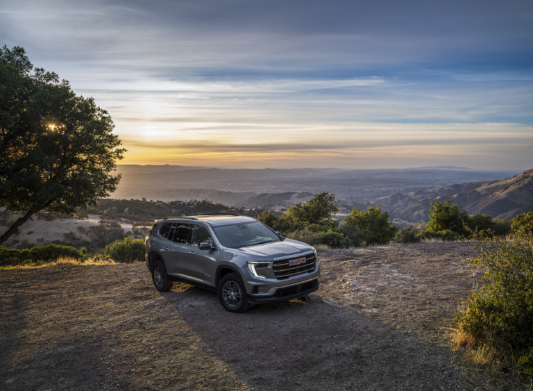 A GMC Acadia is standing in an open space on a flat cliff