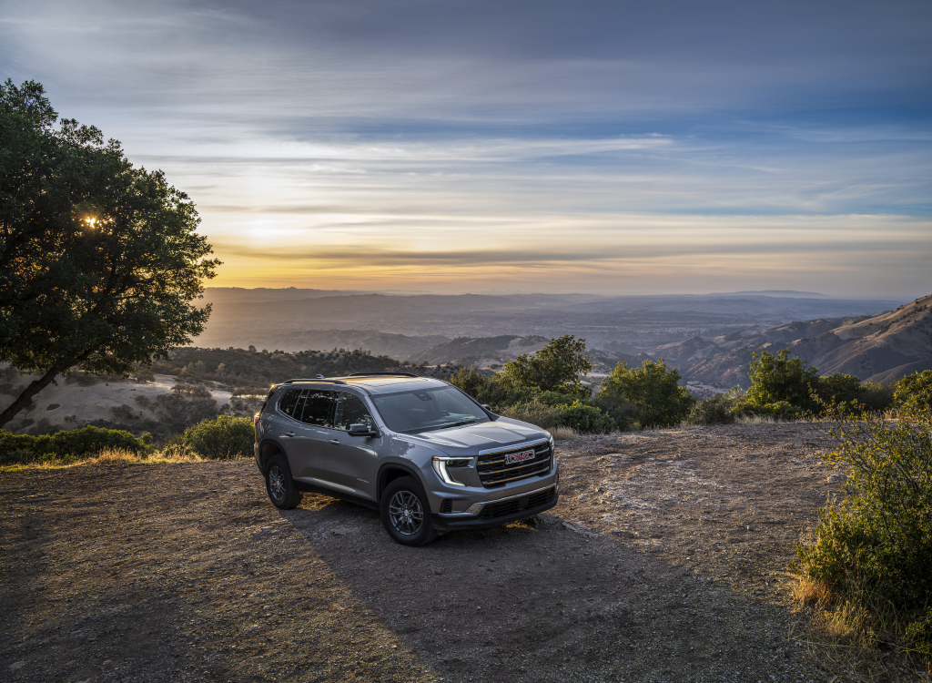 A GMC Acadia is standing in an open space on a flat cliff