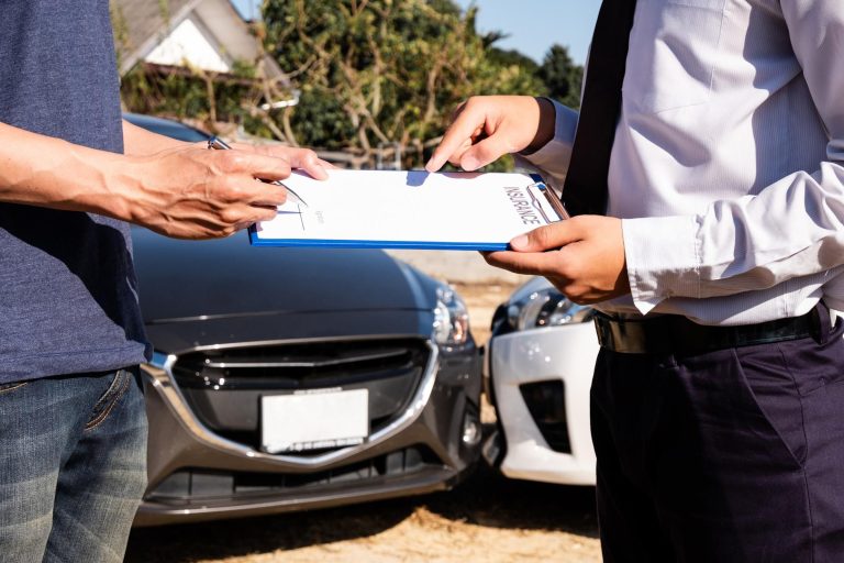 Dealer presenting certified warranty paperwork to customer beside used vehicle