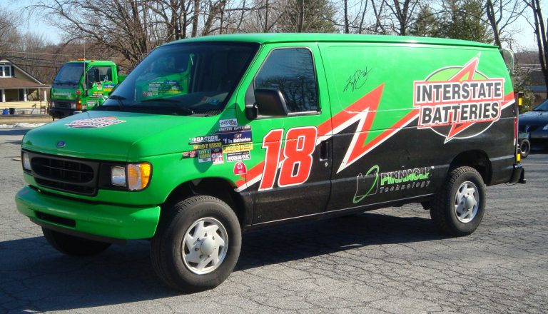 A Green Ford truck is standing with Interstate batteries logo