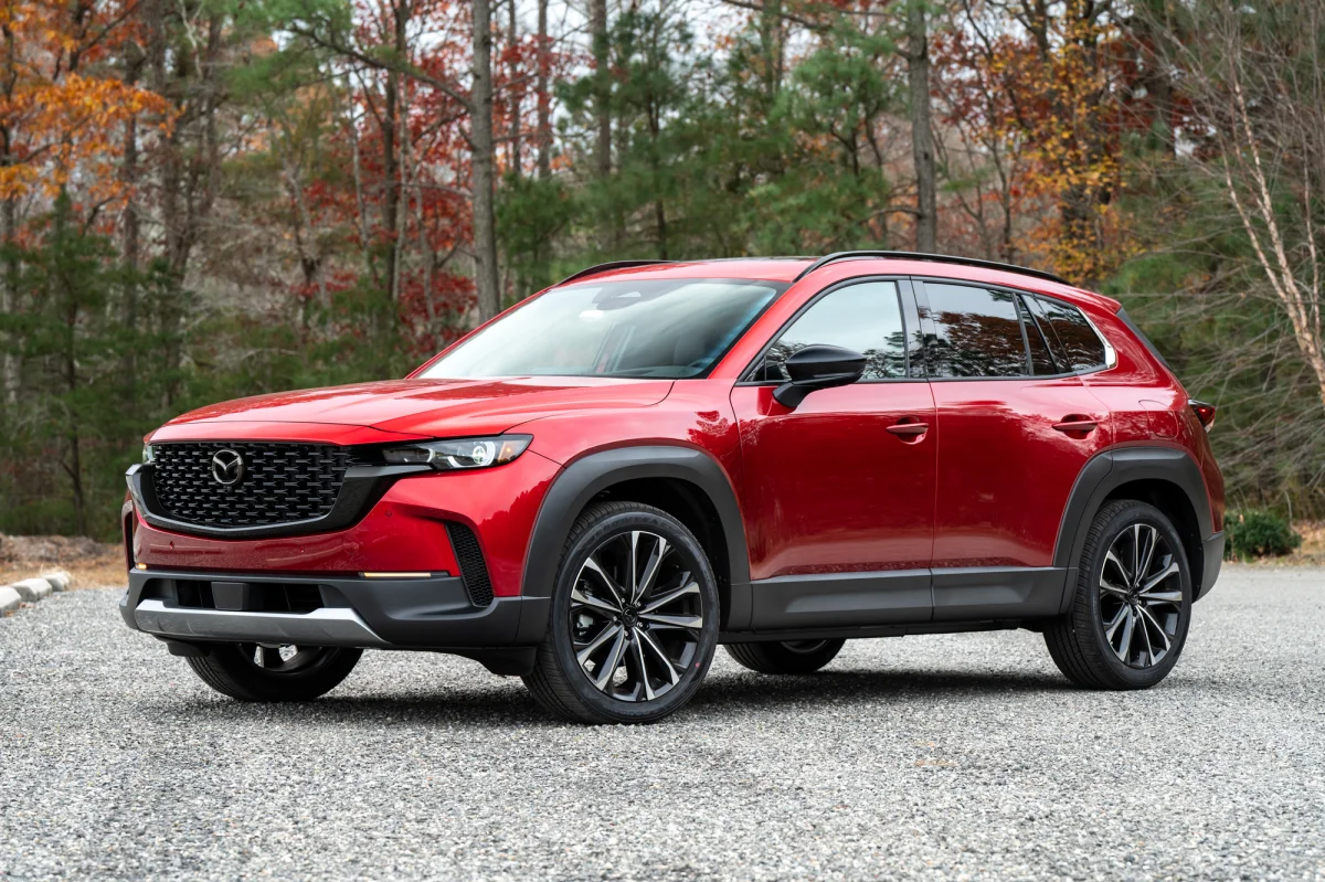 A red Mazda CX-50 is standing on a fresh road in front of cars