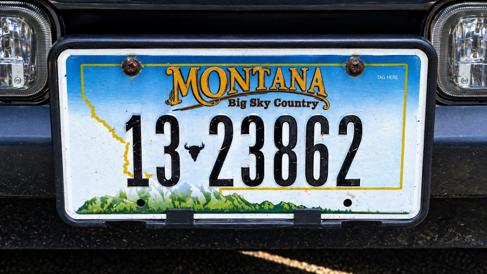 Close-up of a Montana license plate reading “13 23862” mounted on a dark vehicle.