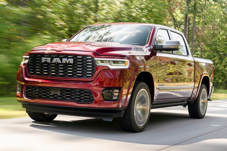 Ram 1500 pickup driving along a scenic forest road