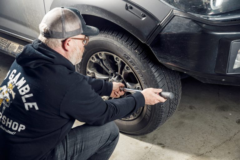A nab is trying to fix the tire of his car