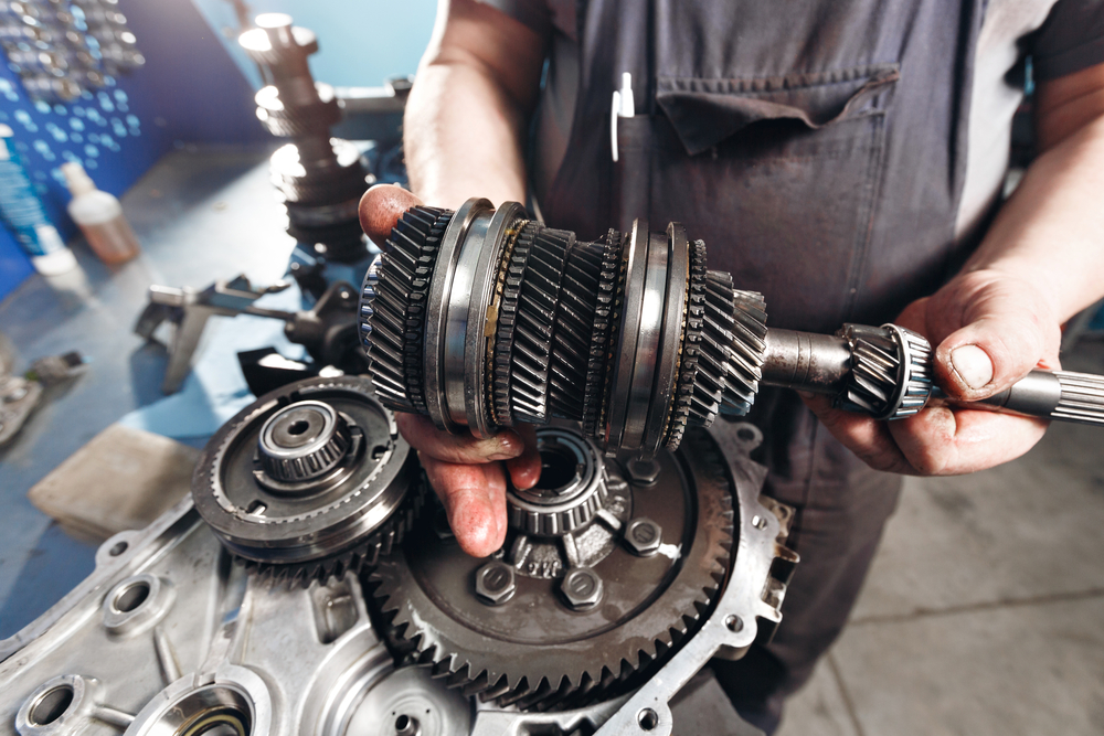 A man is showing the parts of transmission and also the repair portion