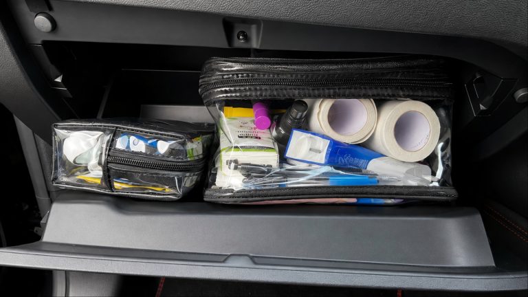 A glove box is shown with plenty of stuff
