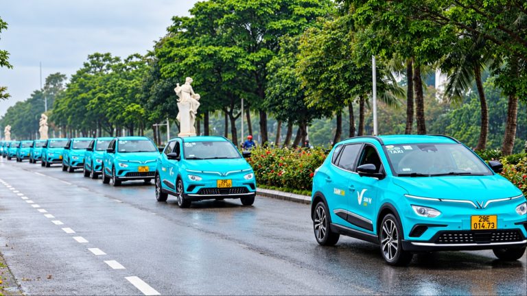 A lineup of turquoise VinFast electric taxis parked along a tree-lined city street