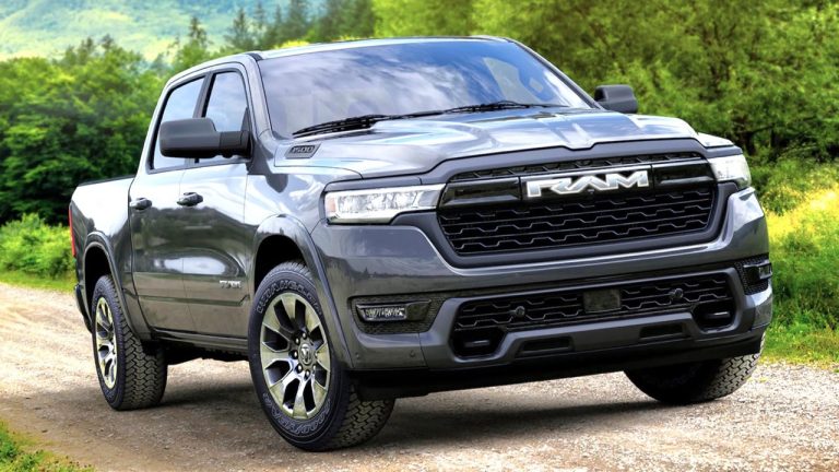 A Ram 1500 pickup truck is parked on a scenic dirt road surrounded by lush green woodland