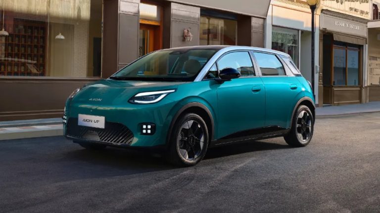 AION UT electric hatchback parked along a stylish urban street with storefronts