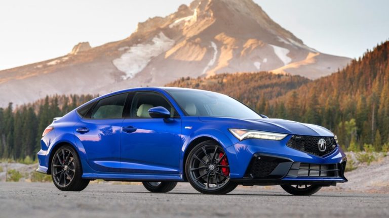 Blue Acura Integra Type S parked against a scenic mountain backdrop