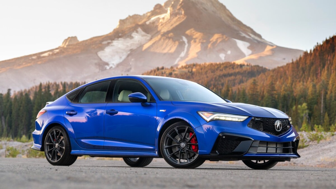 Blue Acura Integra Type S parked against a scenic mountain backdrop