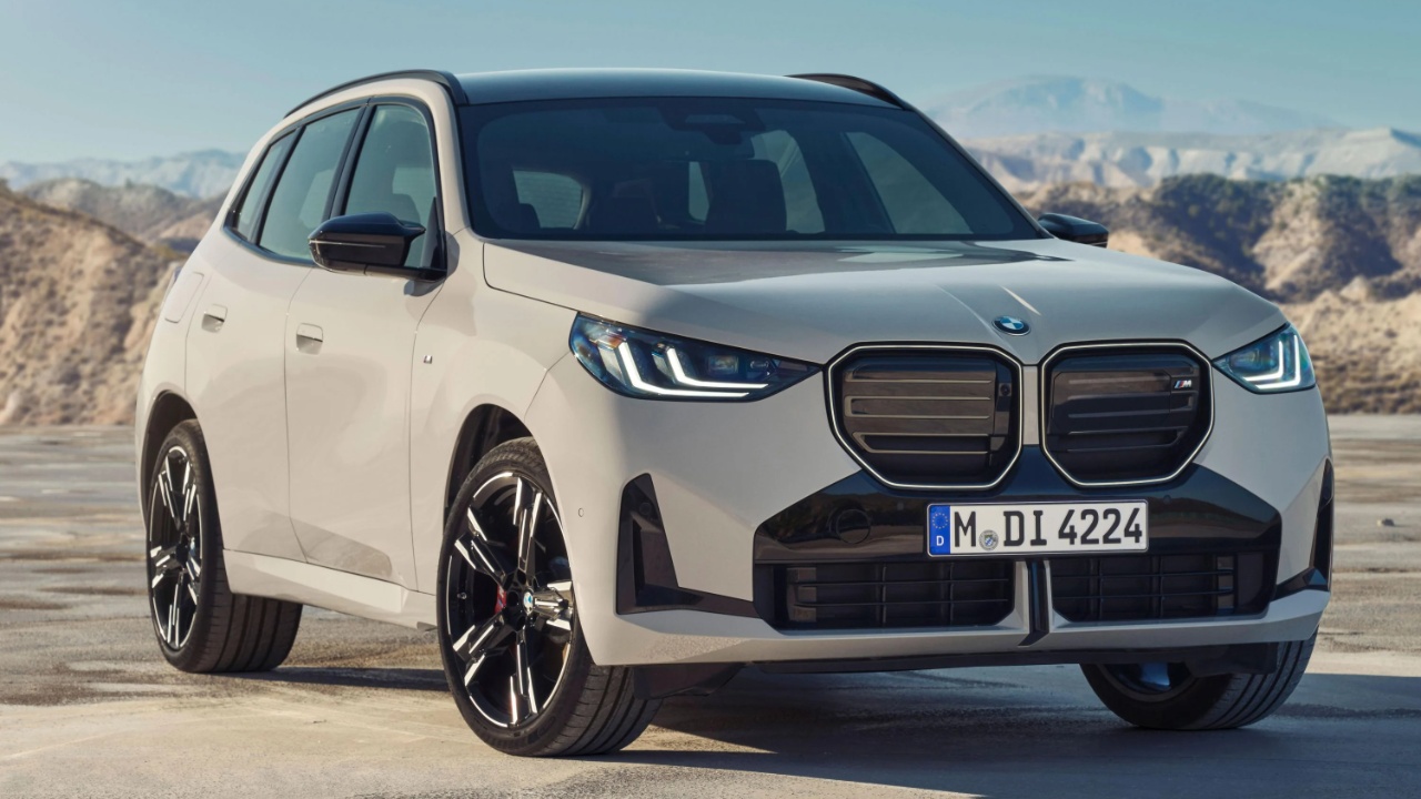 BMW X3 parked against a dramatic mountain landscape on a sunny day