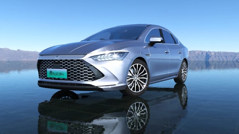 BYD Qin Plus DM-i parked beside a calm lake, with mountains in the background