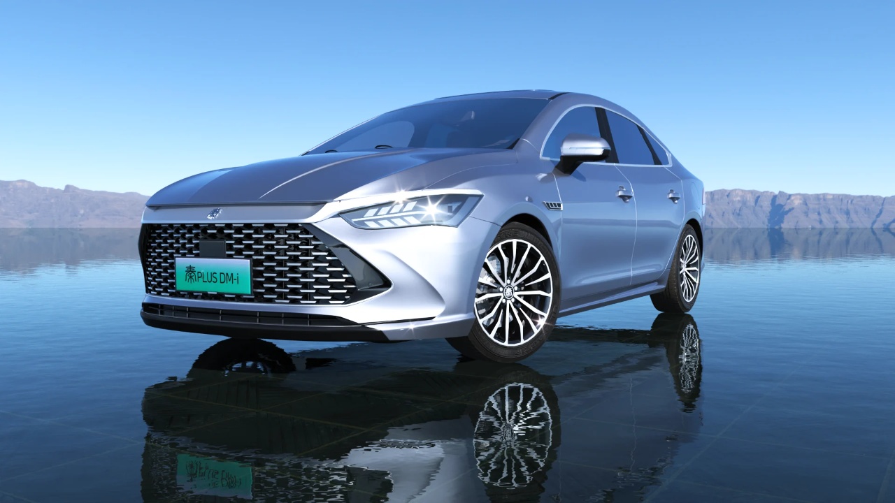 BYD Qin Plus DM-i parked beside a calm lake, with mountains in the background