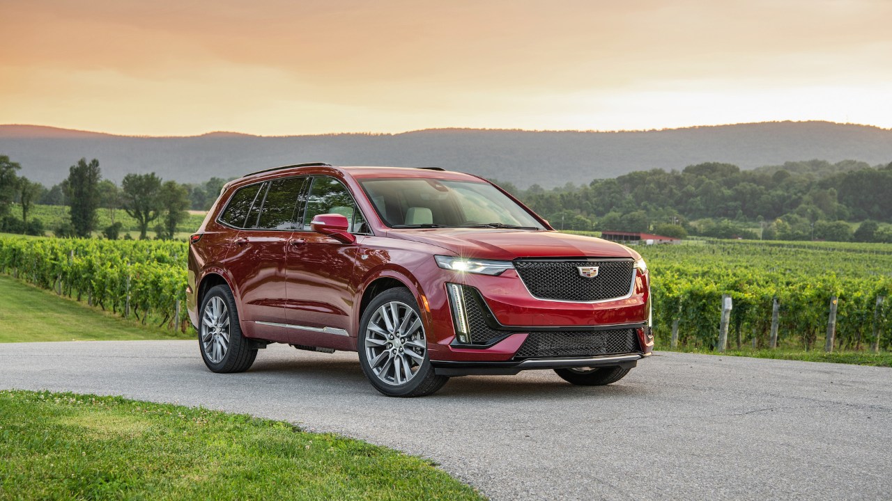 Cadillac XT6 parked on a scenic road surrounded by vineyards and mountains