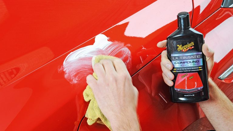 Car owner applying polishing compound to restore and enhance a vehicle’s glossy paint finish