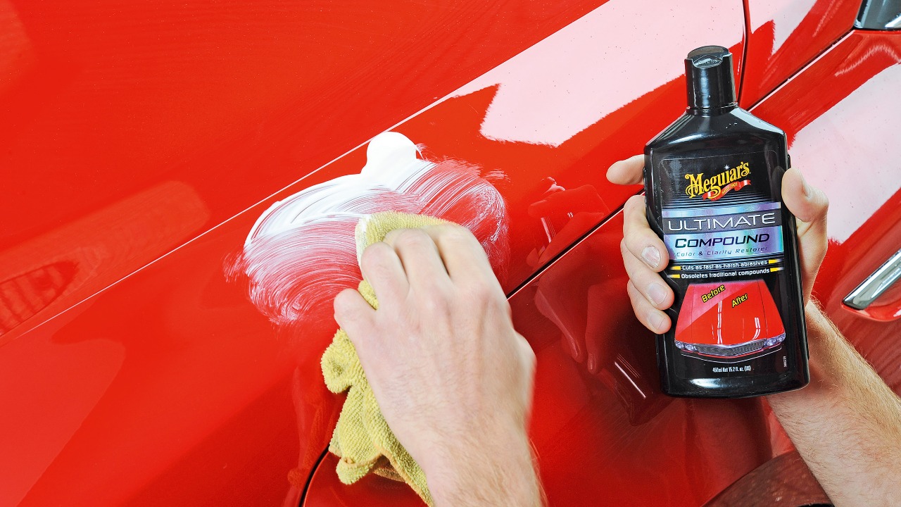 Car owner applying polishing compound to restore and enhance a vehicle’s glossy paint finish