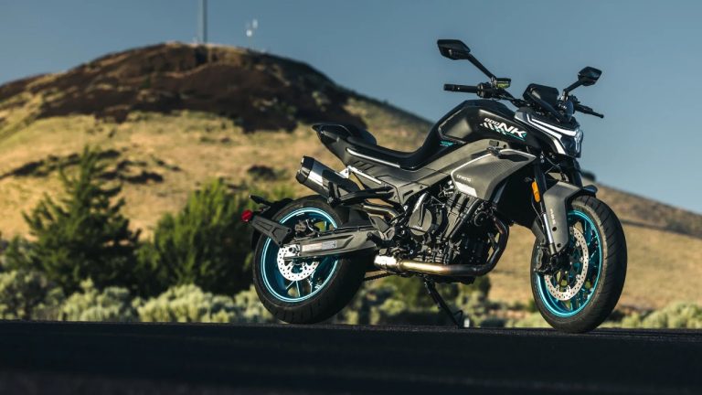 CFMOTO motorcycle parked on a mountain road with rugged hills behind it