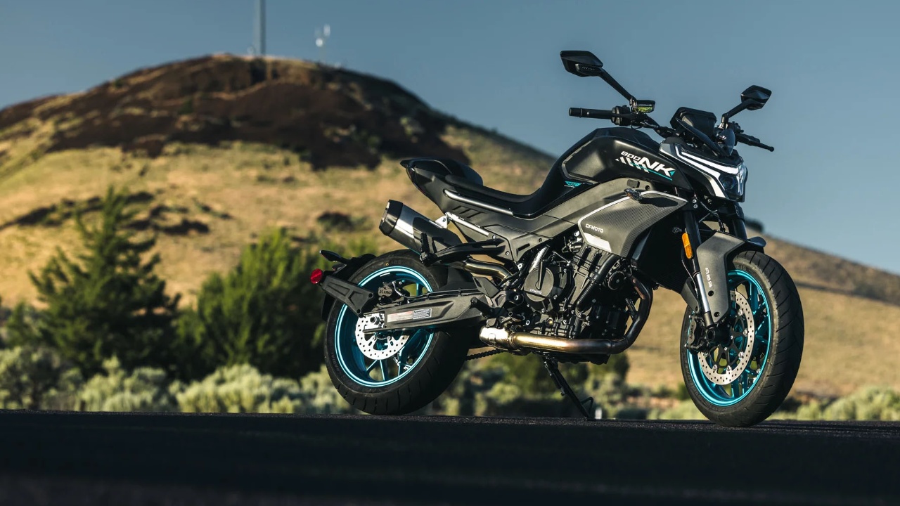 CFMOTO motorcycle parked on a mountain road with rugged hills behind it