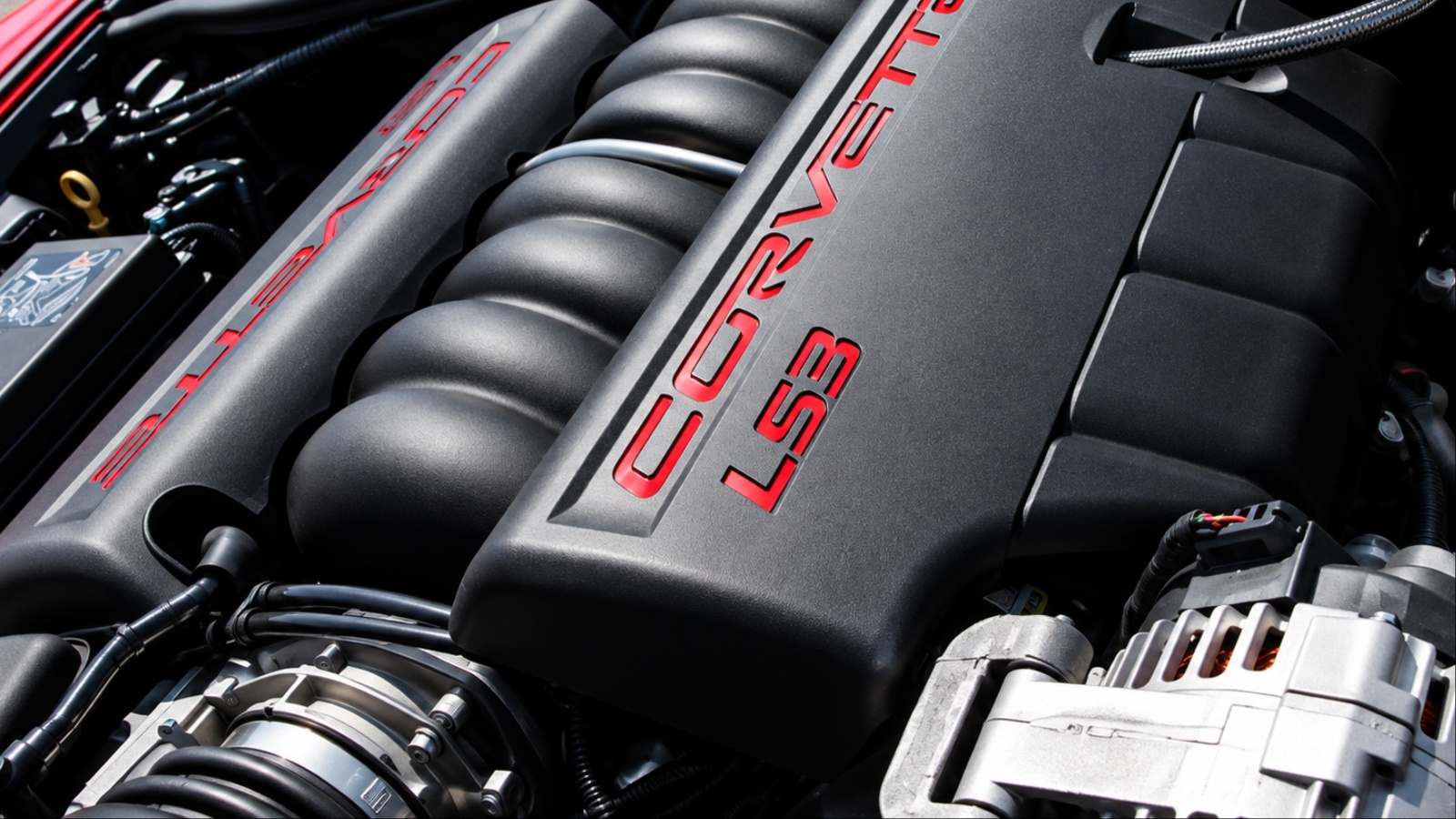 Close-up of black Corvette LS3 V8 engine cover with red logos