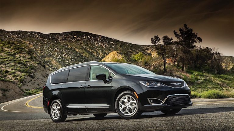 Chrysler Pacifica parked on a winding mountain road beneath dramatic skies