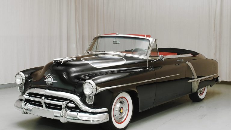 Classic 1950s convertible showcasing elegant styling, chrome details, and whitewall tires