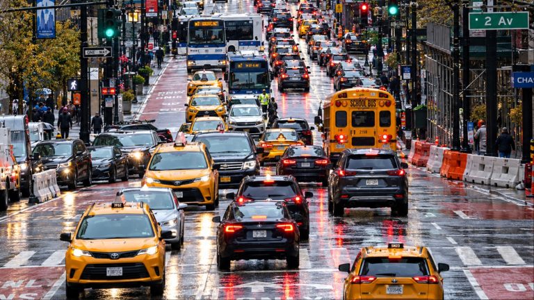 Busy rainy New York City street filled with yellow taxis