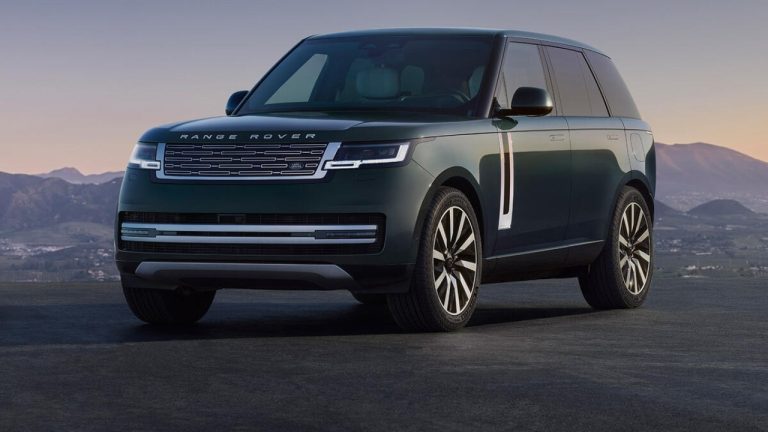 Dark green Range Rover Electric SUV parked against a dramatic mountain backdrop