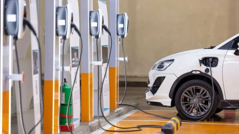 Electric vehicle charges at a public station with multiple chargers