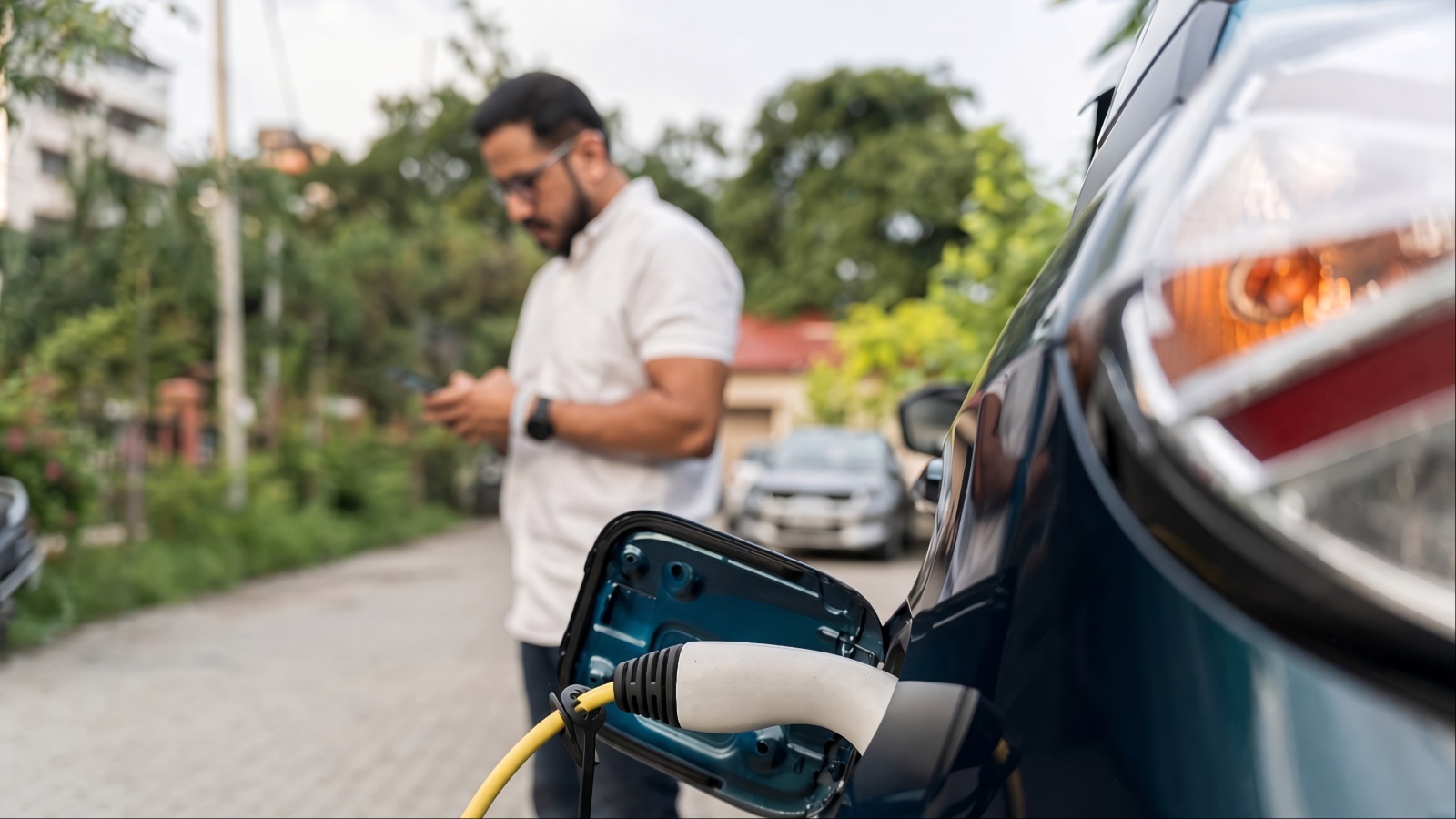 Electric vehicle charging, with the driver waiting nearby