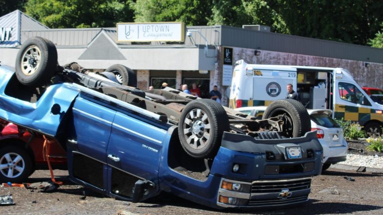 Federal crash investigators examine an overturned Chevrolet pickup after a serious road accident
