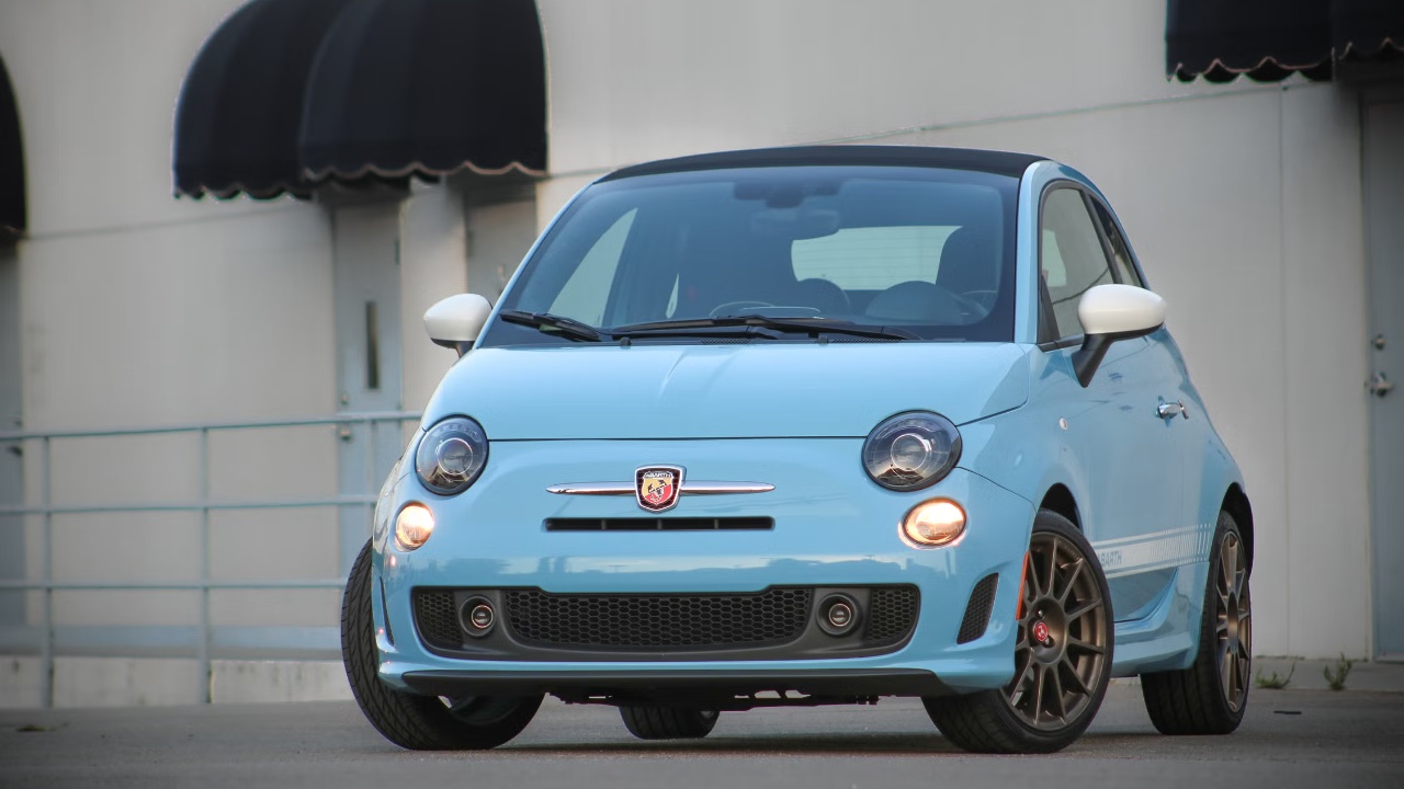 Fiat 500 Abarth parked outside a building, showcasing its sporty stance and compact design