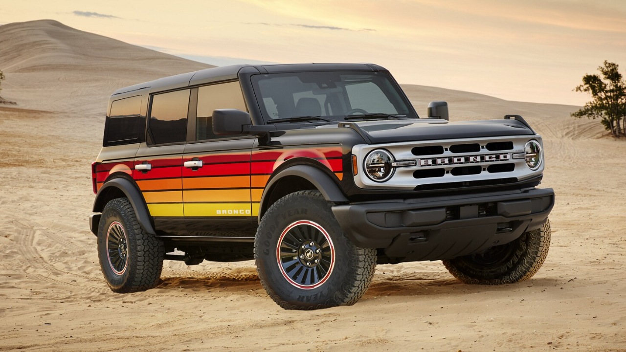 Ford Bronco parked on sandy dunes, showcasing rugged off-road styling and capabilities