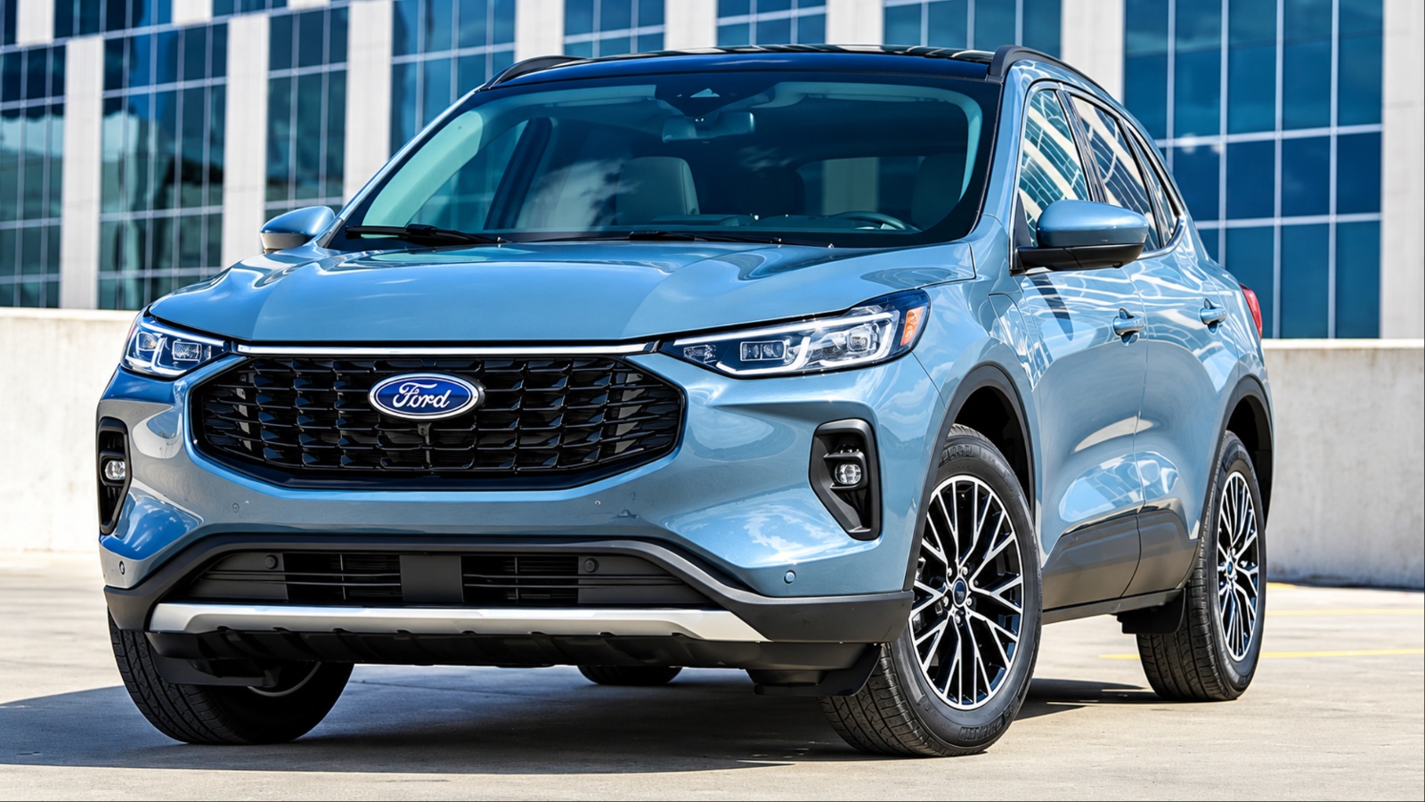 Light blue Ford Escape SUV parked outdoors near modern building
