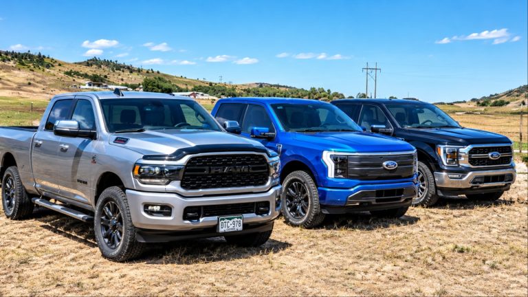 Three pickup trucks Ram and two Fords parked in field