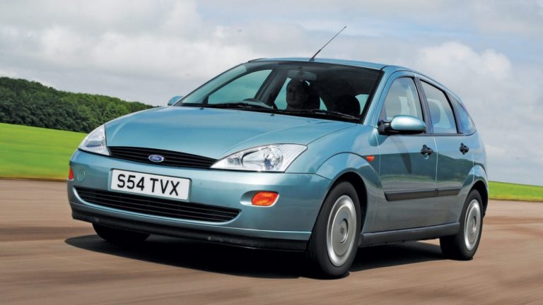 Ford Focus Mk1 driving along a scenic countryside road under partly cloudy skies