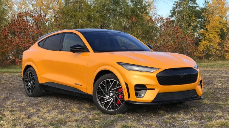 Ford Mustang Mach-E parked outdoors with vibrant orange paint and black accents