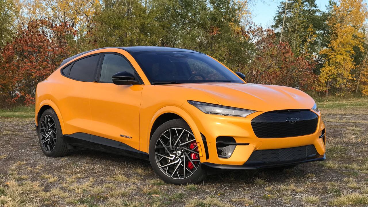 Ford Mustang Mach-E parked outdoors with vibrant orange paint and black accents