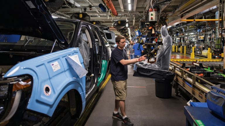 Ford vehicle being assembled by workers on a modern production line