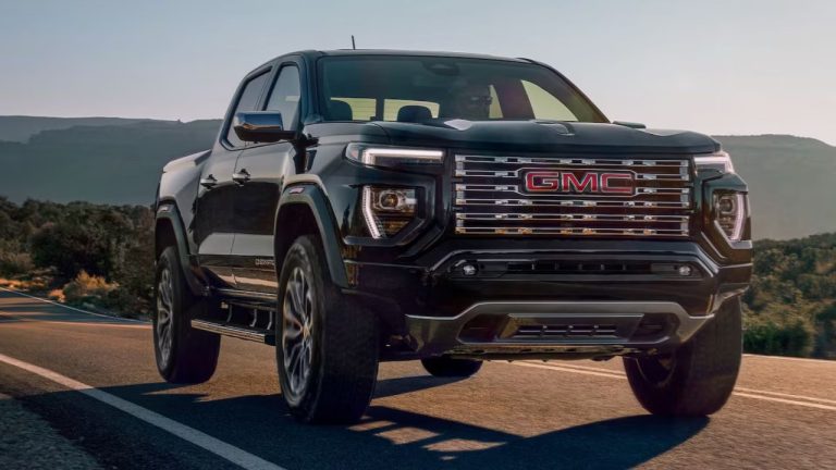 GMC Canyon driving along a scenic mountain highway at sunset
