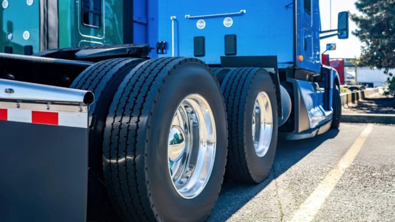 Heavy-duty truck rear axle and tires showcased in a close-up industrial setting