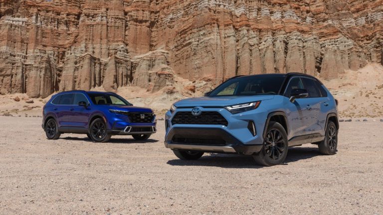 Honda CR-V and Toyota RAV4 hybrids parked against a rugged canyon backdrop