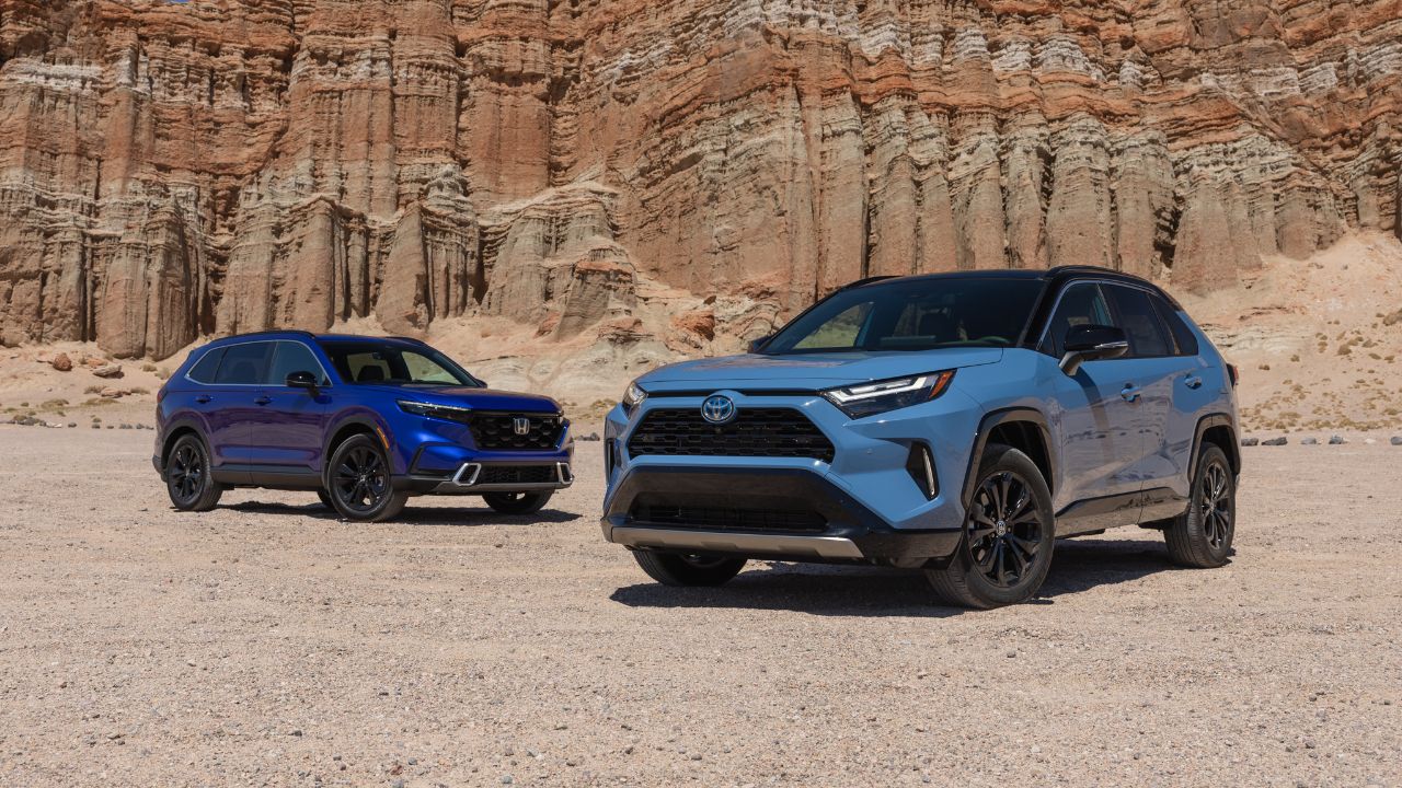 Honda CR-V and Toyota RAV4 hybrids parked against a rugged canyon backdrop